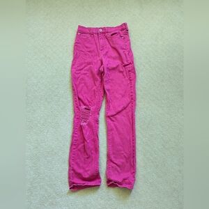 Hot pink jeans with a rip in the knee